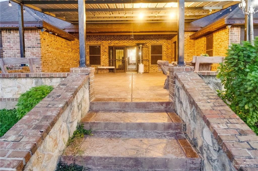 22811 Skinner Road Edcouch, TX 78538 - Photo 34 of 38 Expansive brick patio with a covered outdoor area, brick and stone retaining walls, and built-in steps