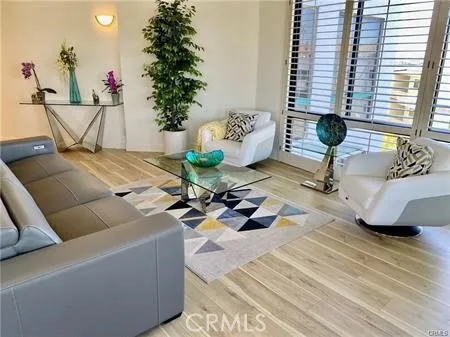 a living room with furniture plant and a large window