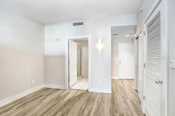 a view of a room with wooden floor and a bathroom