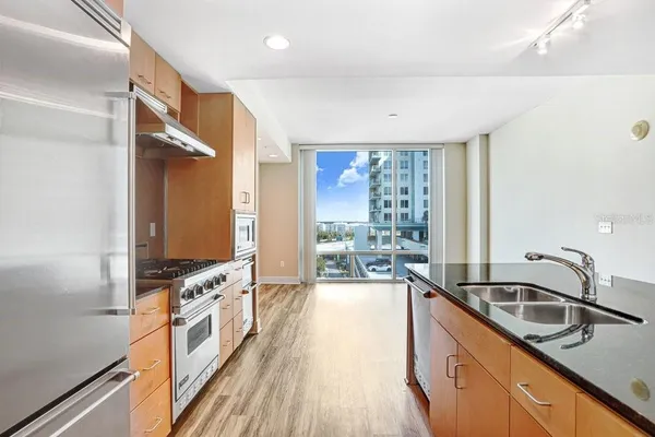 a kitchen with stainless steel appliances granite countertop a sink stove and refrigerator