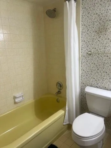 a white toilet and tub sitting next to a bathroom sink