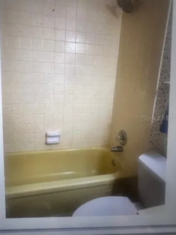 a bathroom with a toilet and a shower curtain