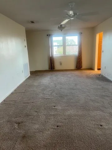 en empty room with windows and fireplace