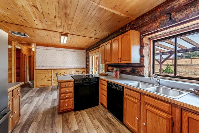 a kitchen with stainless steel appliances granite countertop a sink and wooden floors