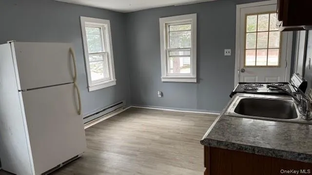 a kitchen with granite countertop a sink stove and refrigerator