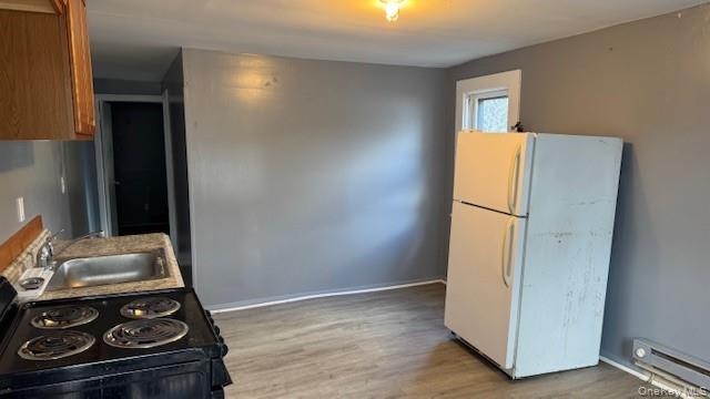 278 Cold Spring Road, Unit 4 Monticello, NY 12701 - Photo 4 of 9 a view of a kitchen with wooden floor and a refrigerator