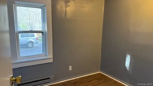 a view of small space with wooden floor and a window