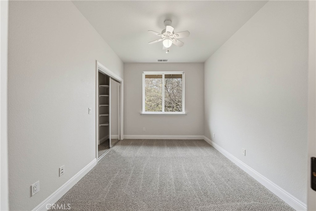 19429 Moon Ridge Road Hidden Valley Lake, CA 95467 - Photo 44 of 75 an empty room with windows and chandelier fan