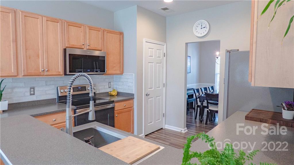 3303 Burnage Hall Road Harrisburg, NC 28075 - Photo 13 of 37 a kitchen with granite countertop a refrigerator and a stove top oven