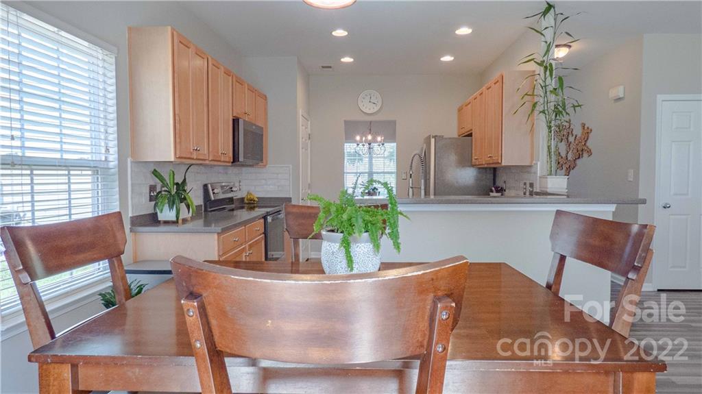 3303 Burnage Hall Road Harrisburg, NC 28075 - Photo 16 of 37 a living room with stainless steel appliances kitchen island granite countertop furniture and a large window