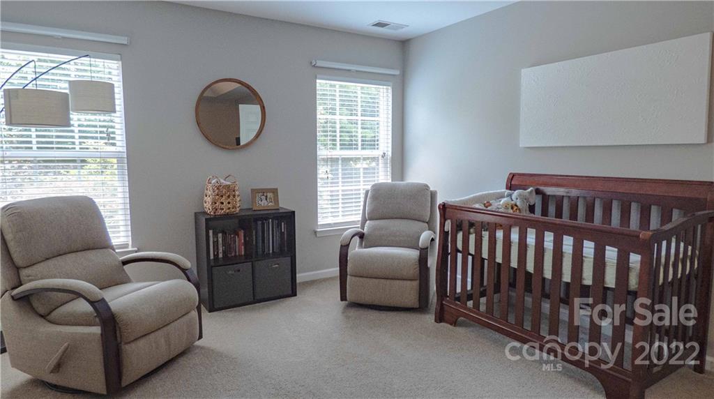 3303 Burnage Hall Road Harrisburg, NC 28075 - Photo 18 of 37 a bedroom with furniture and a large window