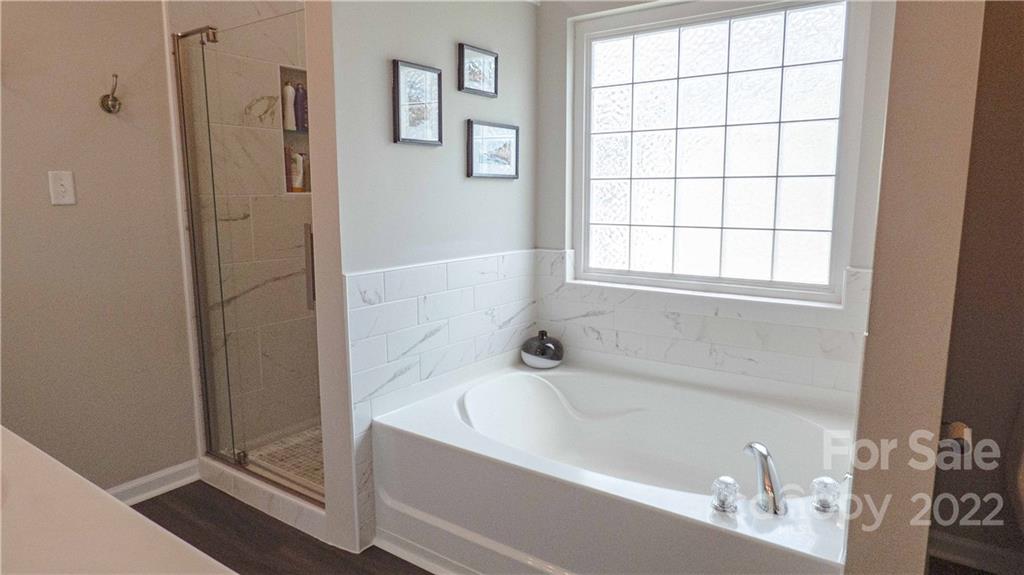 3303 Burnage Hall Road Harrisburg, NC 28075 - Photo 21 of 37 a bathroom with a bathtub and a shower