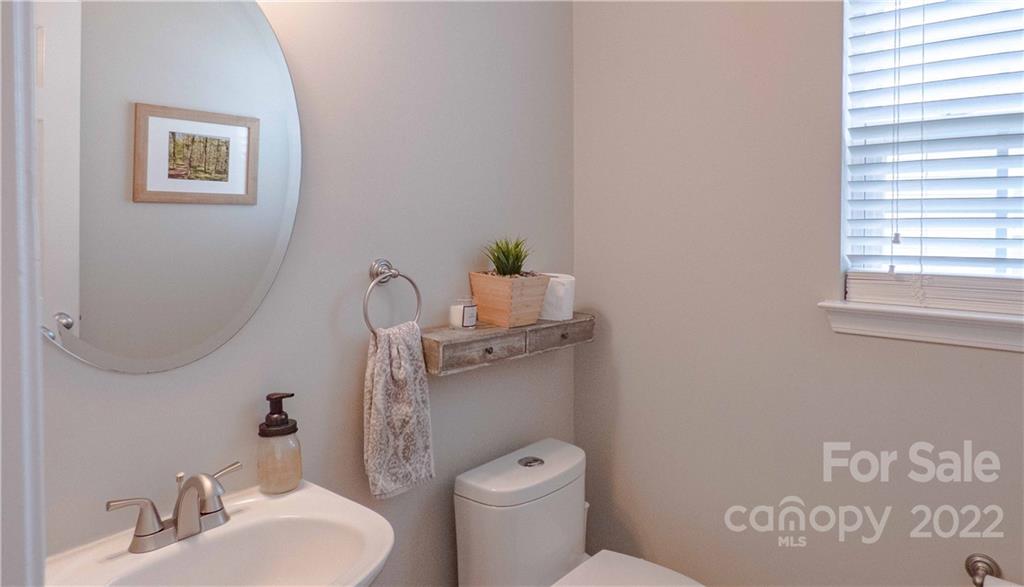 3303 Burnage Hall Road Harrisburg, NC 28075 - Photo 30 of 37 a bathroom with a toilet a sink and a mirror