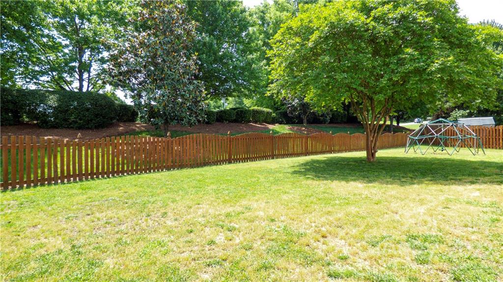 3303 Burnage Hall Road Harrisburg, NC 28075 - Photo 32 of 37 a view of a yard with wooden fence