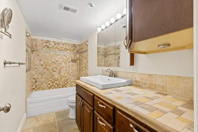 a bathroom with a tub sink and mirror