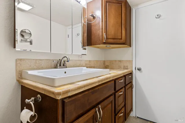 a utility room with sink and mirror