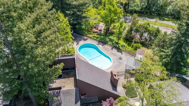 an aerial view of a house with a yard and swimming pool