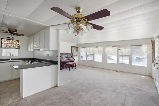 an empty room with windows and fan