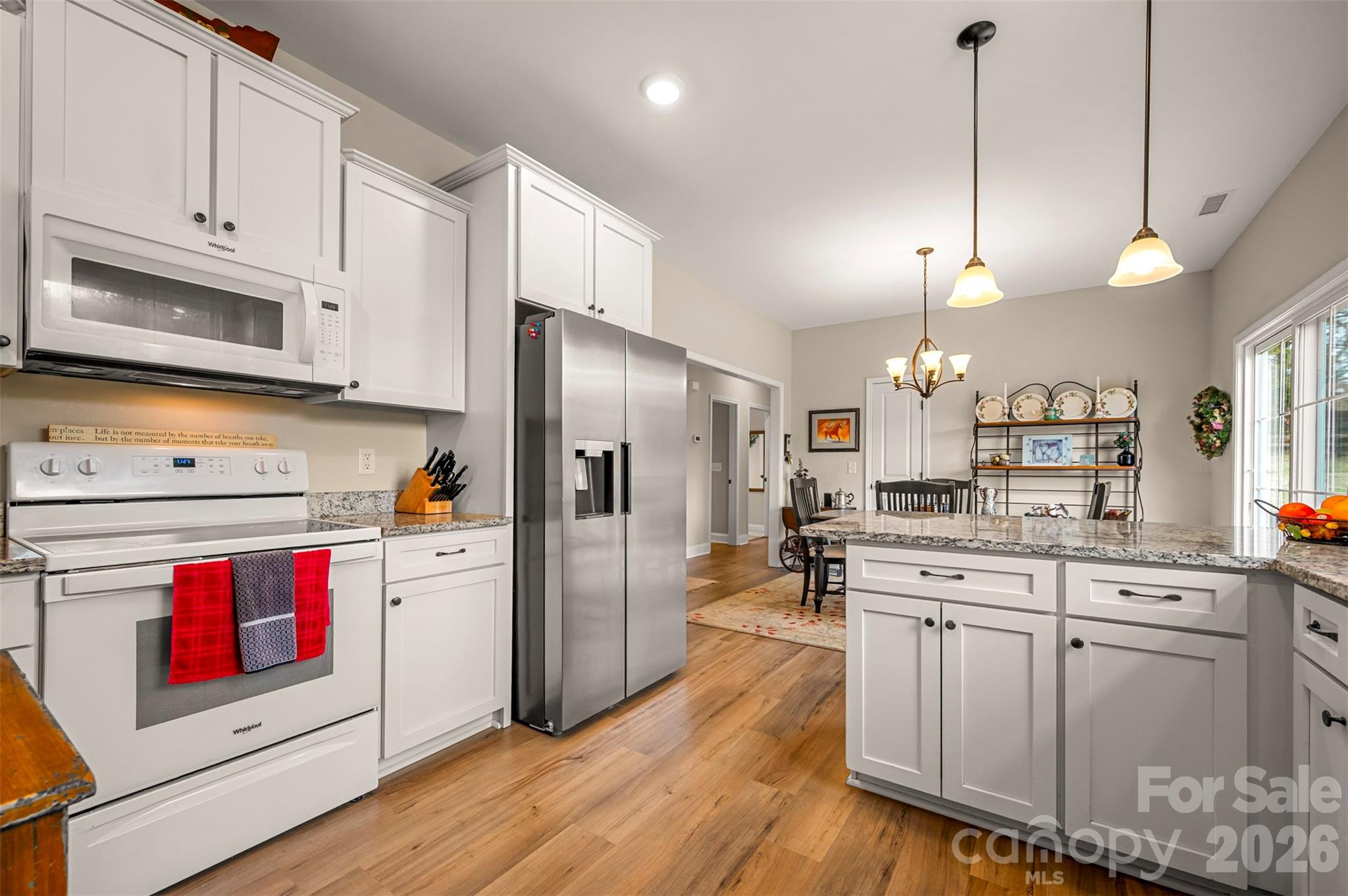 398 David Sims Road Rutherfordton, NC 28139 - Photo 20 of 48 a kitchen with stainless steel appliances kitchen island granite countertop a refrigerator a stove and white cabinets with wooden floors
