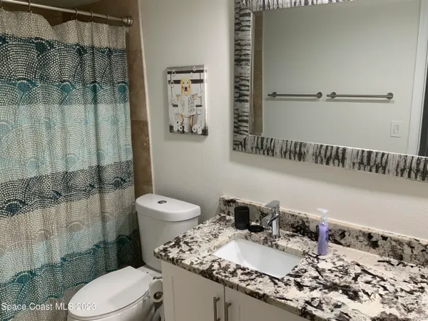 a bathroom with a granite countertop sink toilet and shower