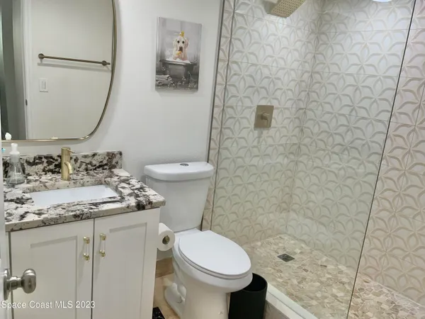 a bathroom with a granite countertop toilet sink and mirror