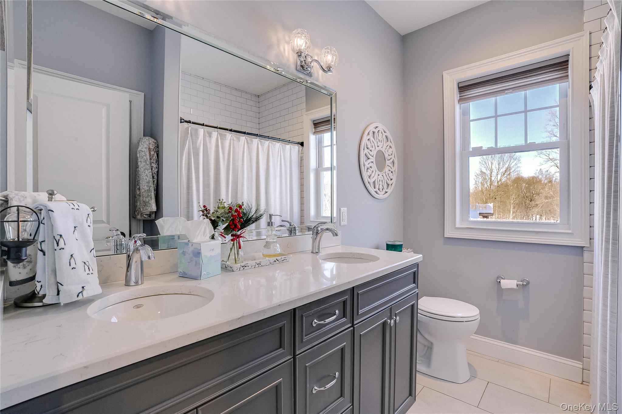 23 Swan Holw Road New Windsor, NY 12553 - Photo 26 of 34 This well-appointed bathroom features a double vanity, a tiled tub, and a spacious closet, combining functionality with style. Thoughtful design and quality finishes make it both practical and inviting.