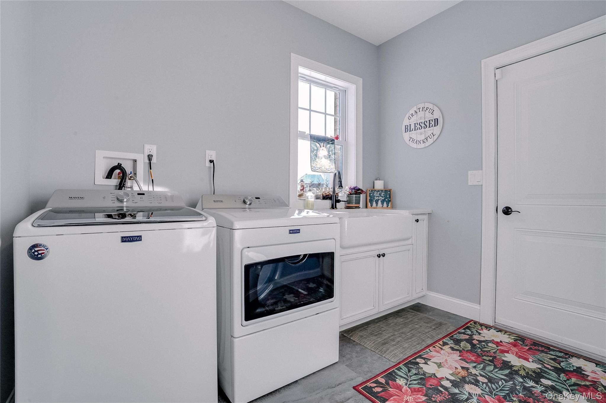 23 Swan Holw Road New Windsor, NY 12553 - Photo 27 of 34 The laundry room is both stylish and functional, equipped with a state-of-the-art washer and dryer and a porcelain sink. Thoughtful design and quality finishes make chores effortless while maintaining the home’s elegant aesthetic.