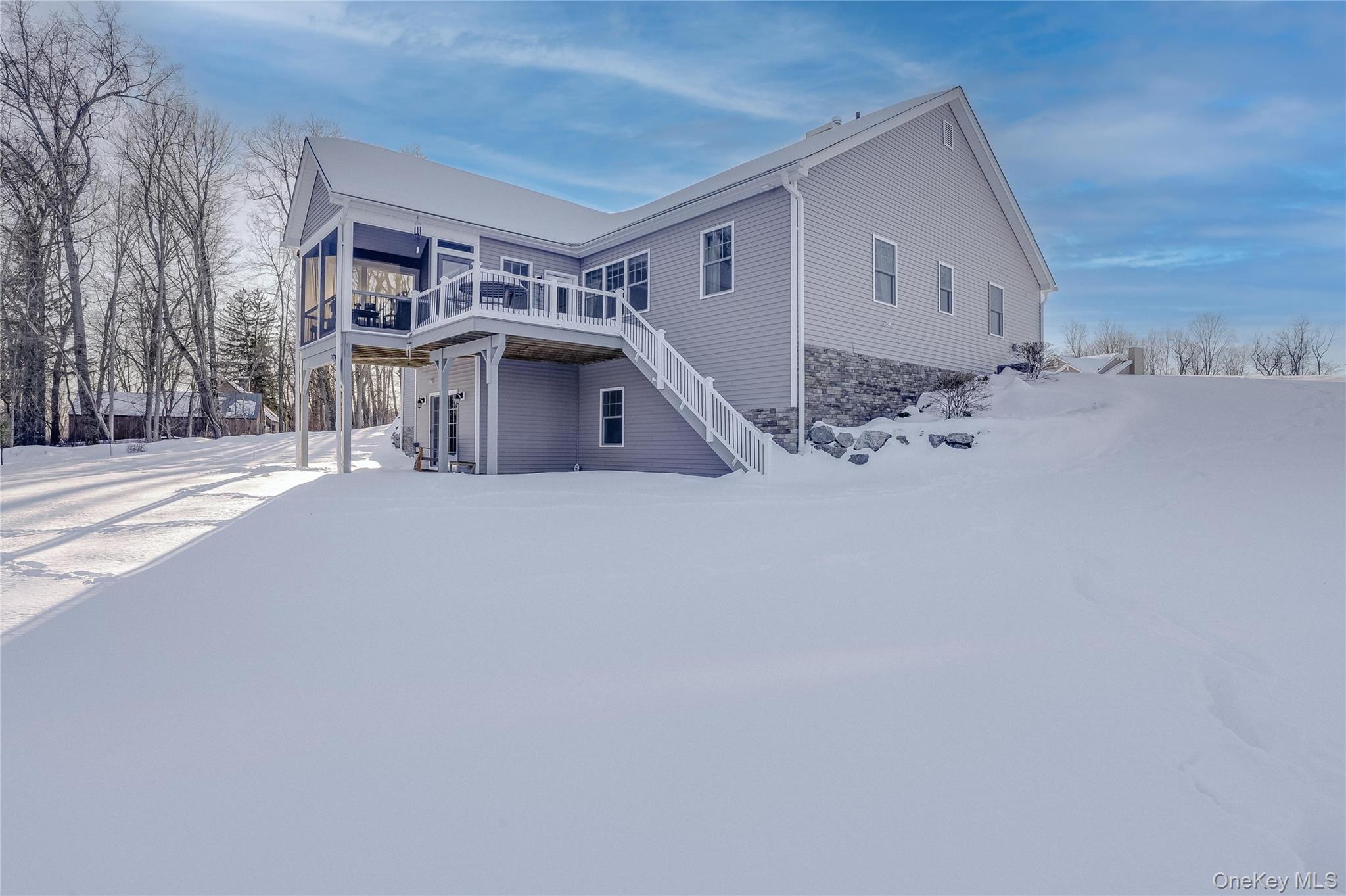 23 Swan Holw Road New Windsor, NY 12553 - Photo 29 of 34 The back of the home features graceful steps that lead directly to the deck and screened-in porch, creating a seamless connection between indoor and outdoor living. This thoughtful design makes entertaining effortless while enjoying the serene views of the surrounding landscape and reservoir.