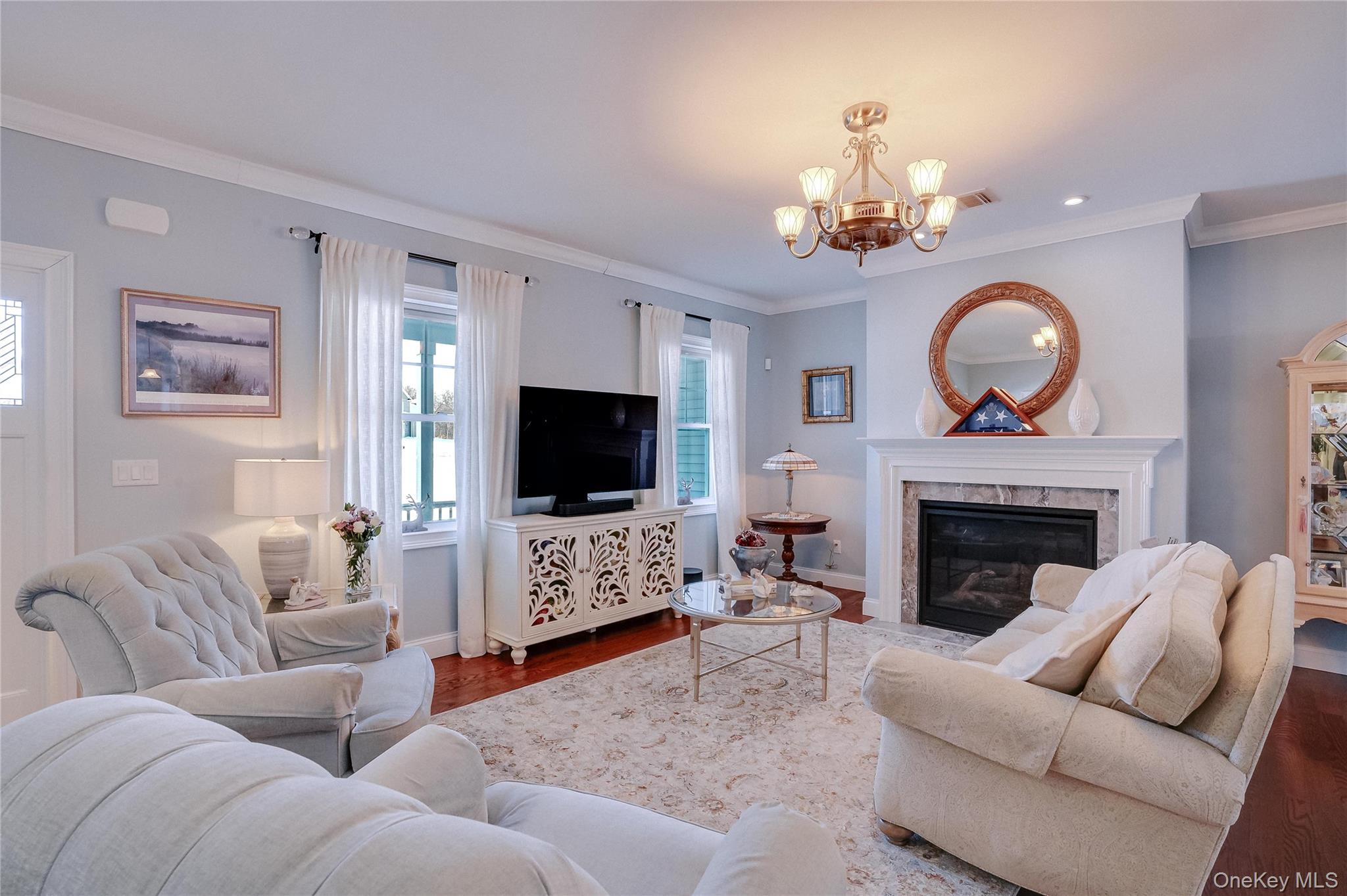23 Swan Holw Road New Windsor, NY 12553 - Photo 7 of 34 The beautiful living room is both inviting and refined, showcasing rich hardwood floors, a cozy gas fireplace, and stunning crown molding that adds architectural depth and timeless elegance.