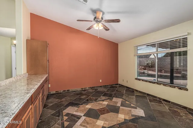 a large kitchen with stainless steel appliances kitchen island granite countertop a refrigerator and microwave