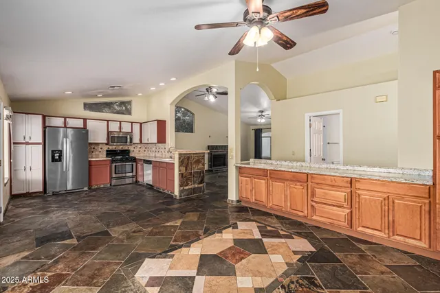 a kitchen with stainless steel appliances granite countertop a refrigerator and a sink