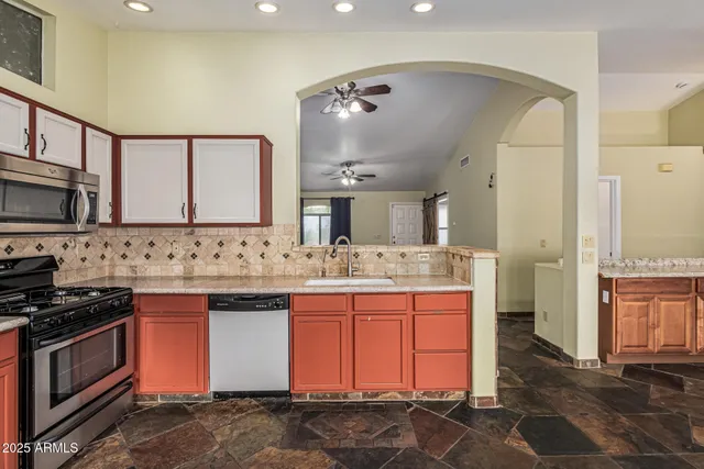 a kitchen with stainless steel appliances granite countertop a refrigerator stove and sink
