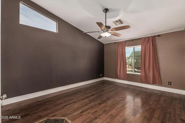 an empty room with wooden floor a ceiling fan and closet