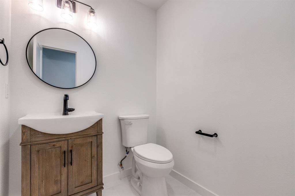 109 East 5th Street Prosper, TX 75078 - Photo 11 of 25 a bathroom with a toilet a sink and mirror