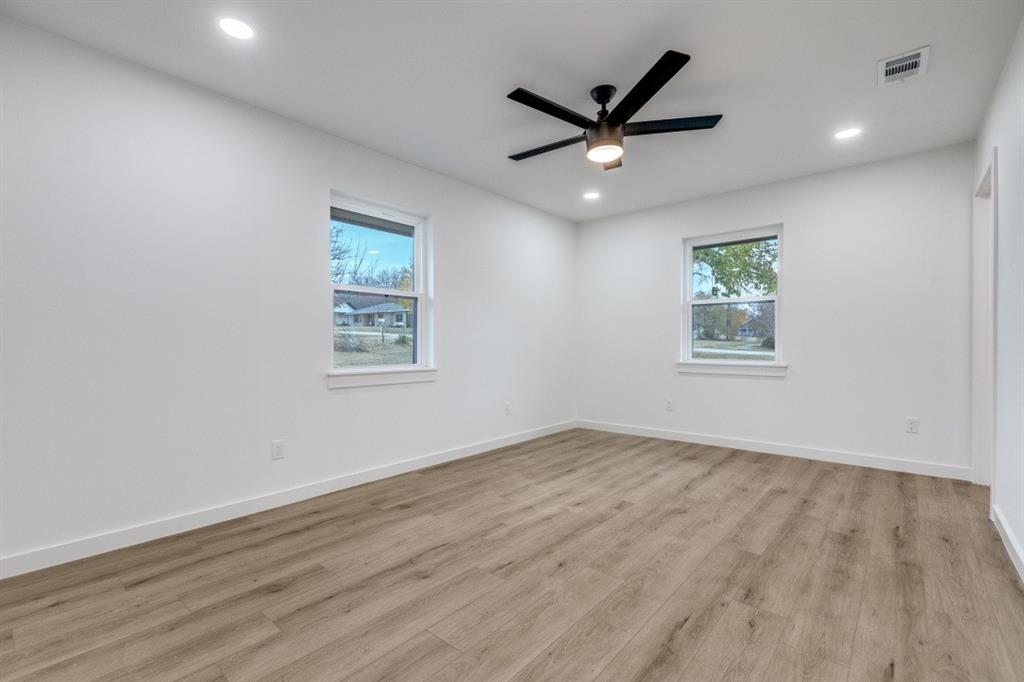 109 East 5th Street Prosper, TX 75078 - Photo 12 of 25 an empty room with wooden floor ceiling fan and window