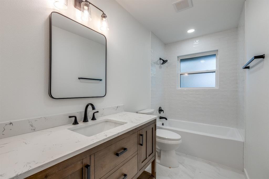 109 East 5th Street Prosper, TX 75078 - Photo 17 of 25 a bathroom with a toilet a sink a mirror and bathtub