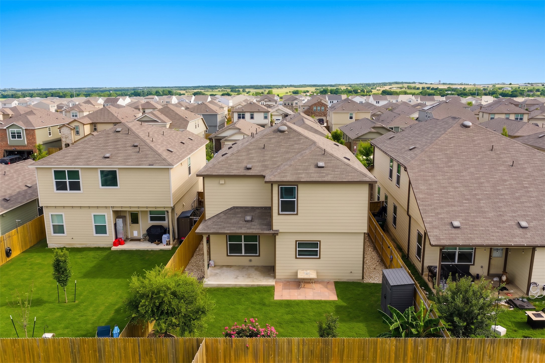 425 Perfect World Loop Jarrell, TX 76537 - Photo 28 of 29 Expansive backyard featuring a manicured lawn, established trees, and a wooden privacy fence