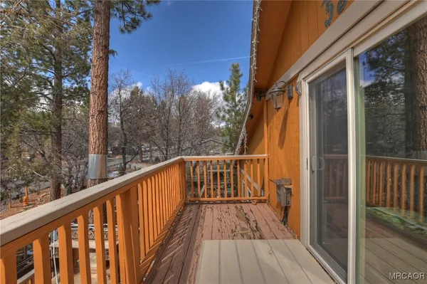 a view of balcony with wooden floor and fence