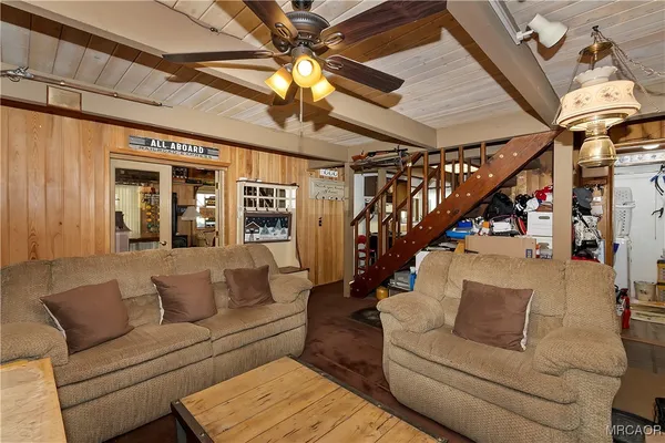 a living room with furniture and a ceiling fan