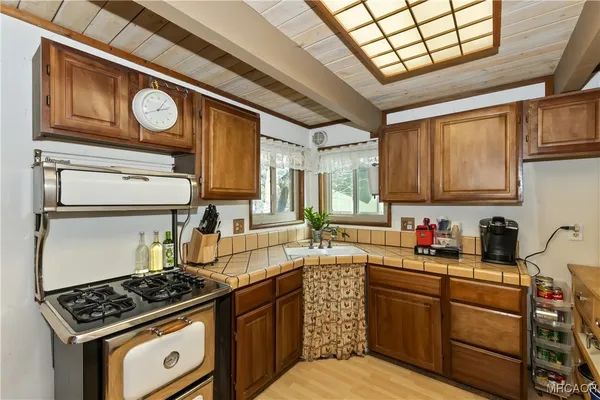 a kitchen with stainless steel appliances granite countertop a stove a sink dishwasher and cabinets with wooden floor