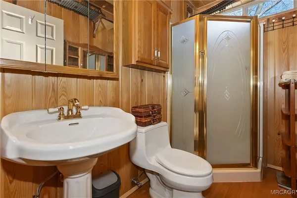 a bathroom with a sink a toilet and shower