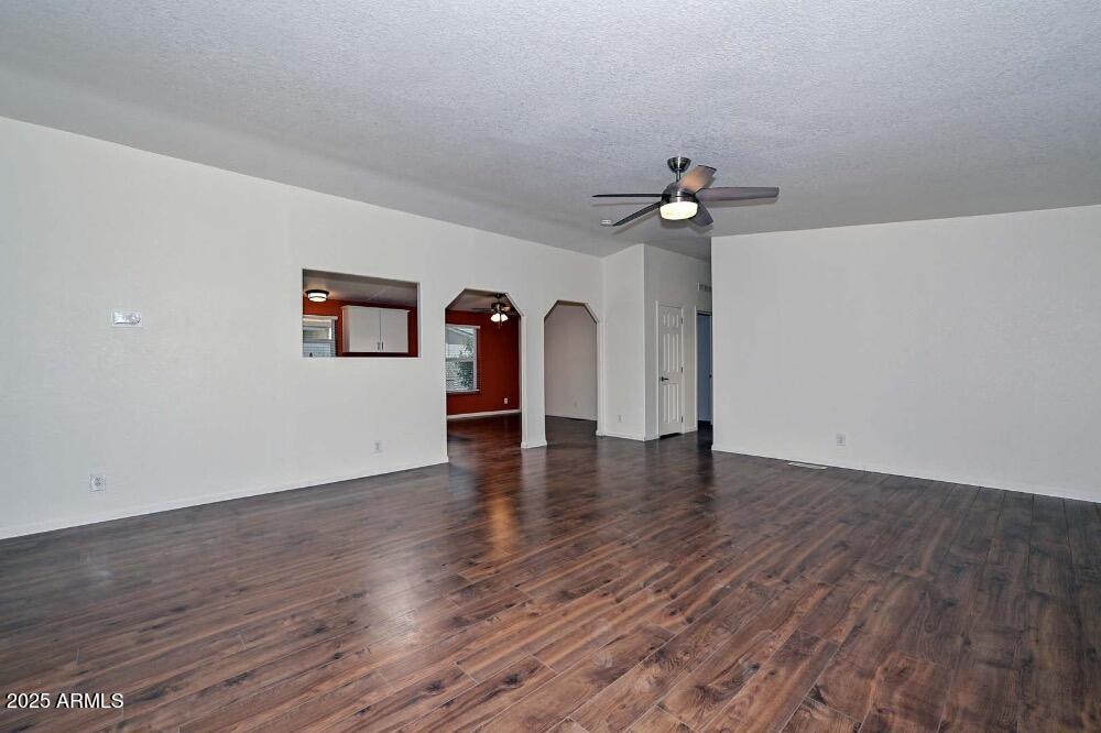 16101 North El Mirage Road, Unit 322 El Mirage, AZ 85335 - Photo 20 of 50 a view of a room with wooden floor a ceiling fan and a chandelier