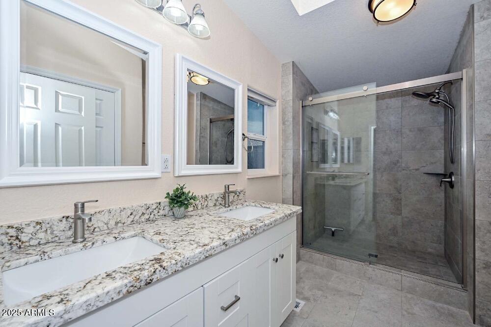 16101 North El Mirage Road, Unit 322 El Mirage, AZ 85335 - Photo 24 of 50 a bathroom with a granite countertop sink mirror and shower