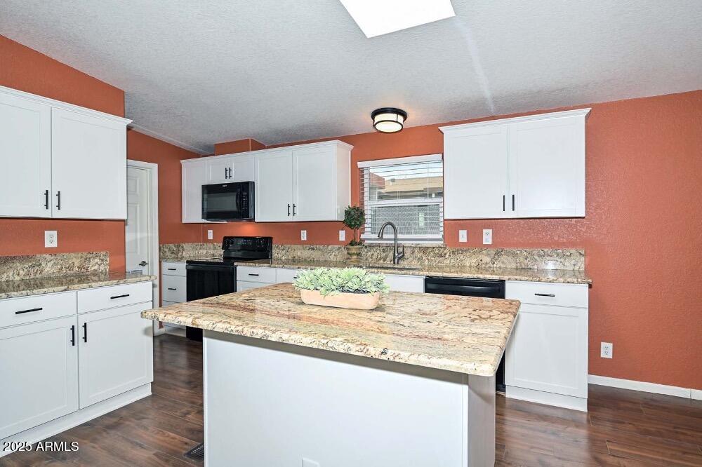 16101 North El Mirage Road, Unit 322 El Mirage, AZ 85335 - Photo 7 of 50 a kitchen with granite countertop cabinets a stove a sink and a counter top space