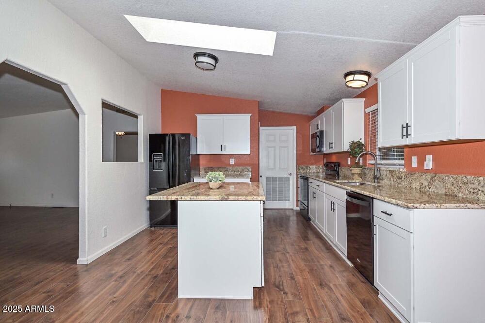 16101 North El Mirage Road, Unit 322 El Mirage, AZ 85335 - Photo 9 of 50 a kitchen with stainless steel appliances kitchen island wooden floors and wooden cabinets
