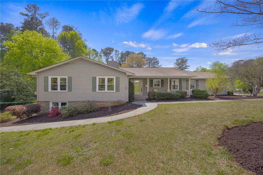 This charming home offers a welcoming facade with a well-maintained lawn and mature landscaping.