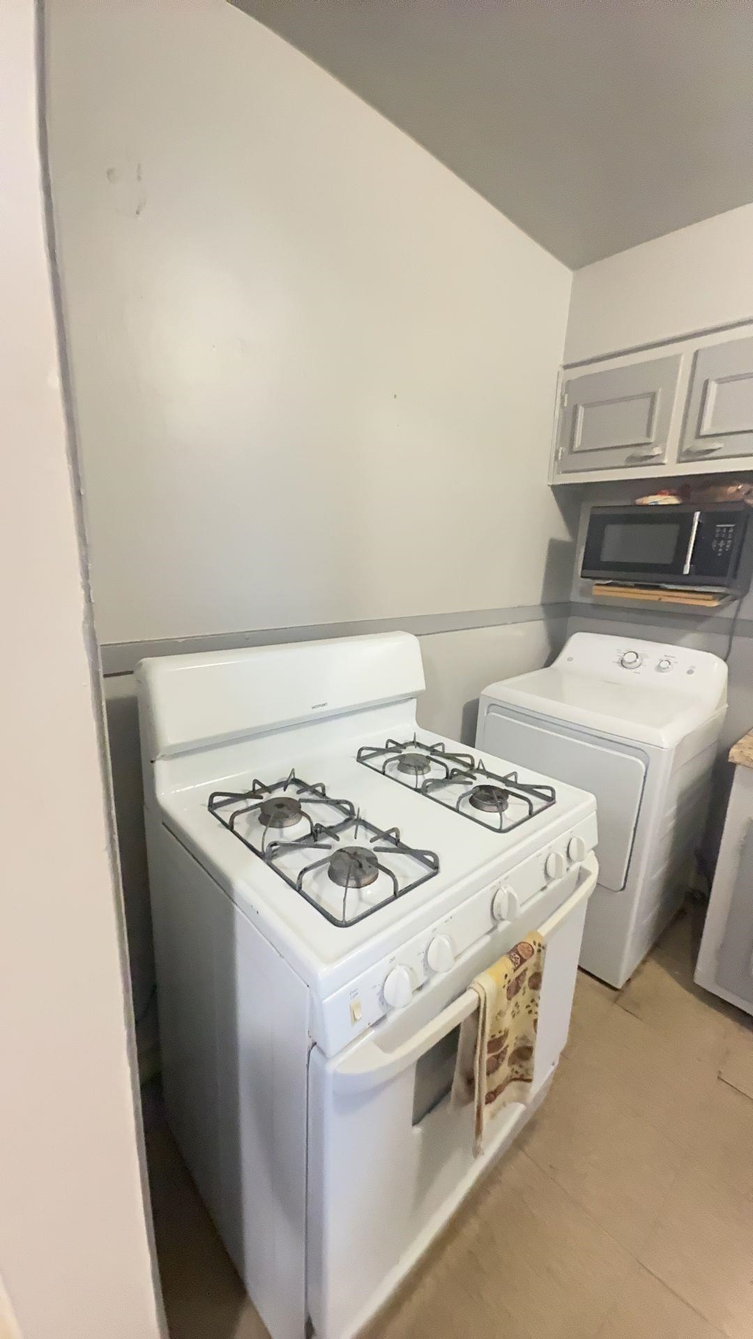 1148 Mt Vernon Road Memphis, TN 38111 - Photo 9 of 17 White gas range with four burners, accompanied by a white dryer