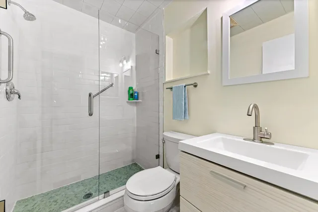 a bathroom with a sink a toilet and shower
