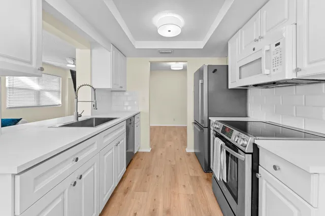 a kitchen with granite countertop a sink stove and refrigerator