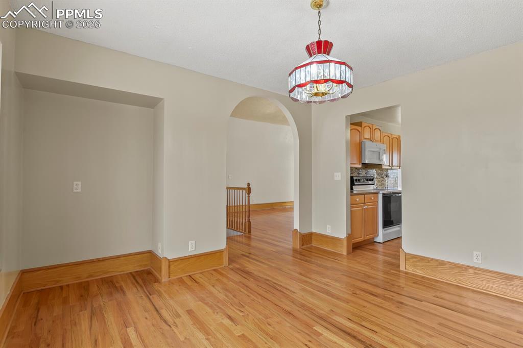 11505 Salinas Road Peyton, CO 80831 - Photo 14 of 37 Dining room with arched walkways and wood finished floors